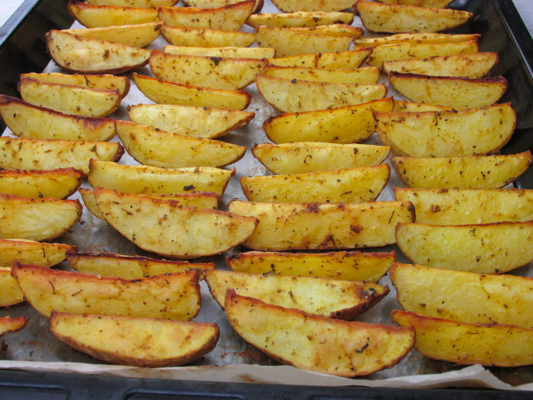 A tray of crisp roasted potatoes with browned edges
