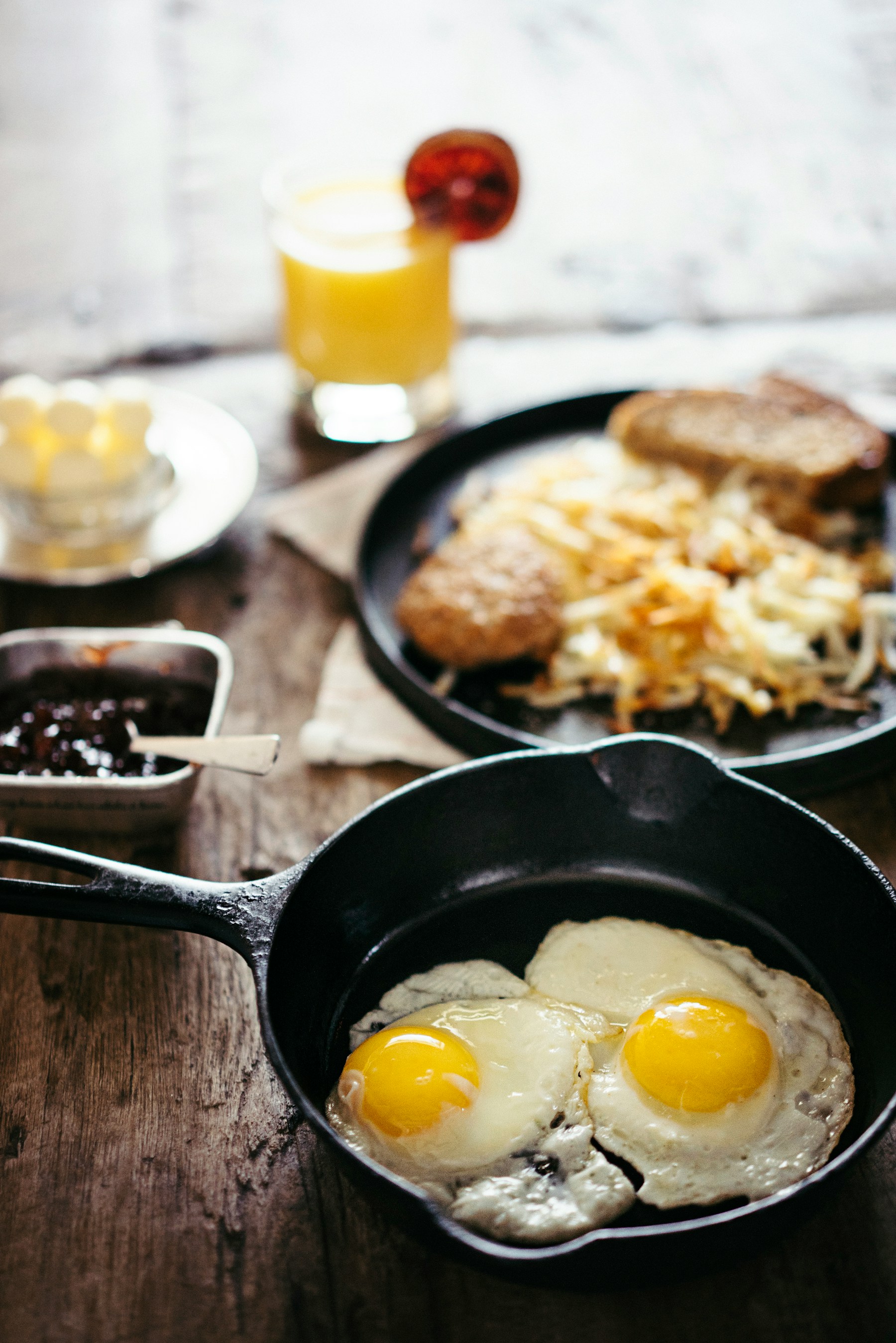 Two fried eggs cooking in a cast-iron skillet