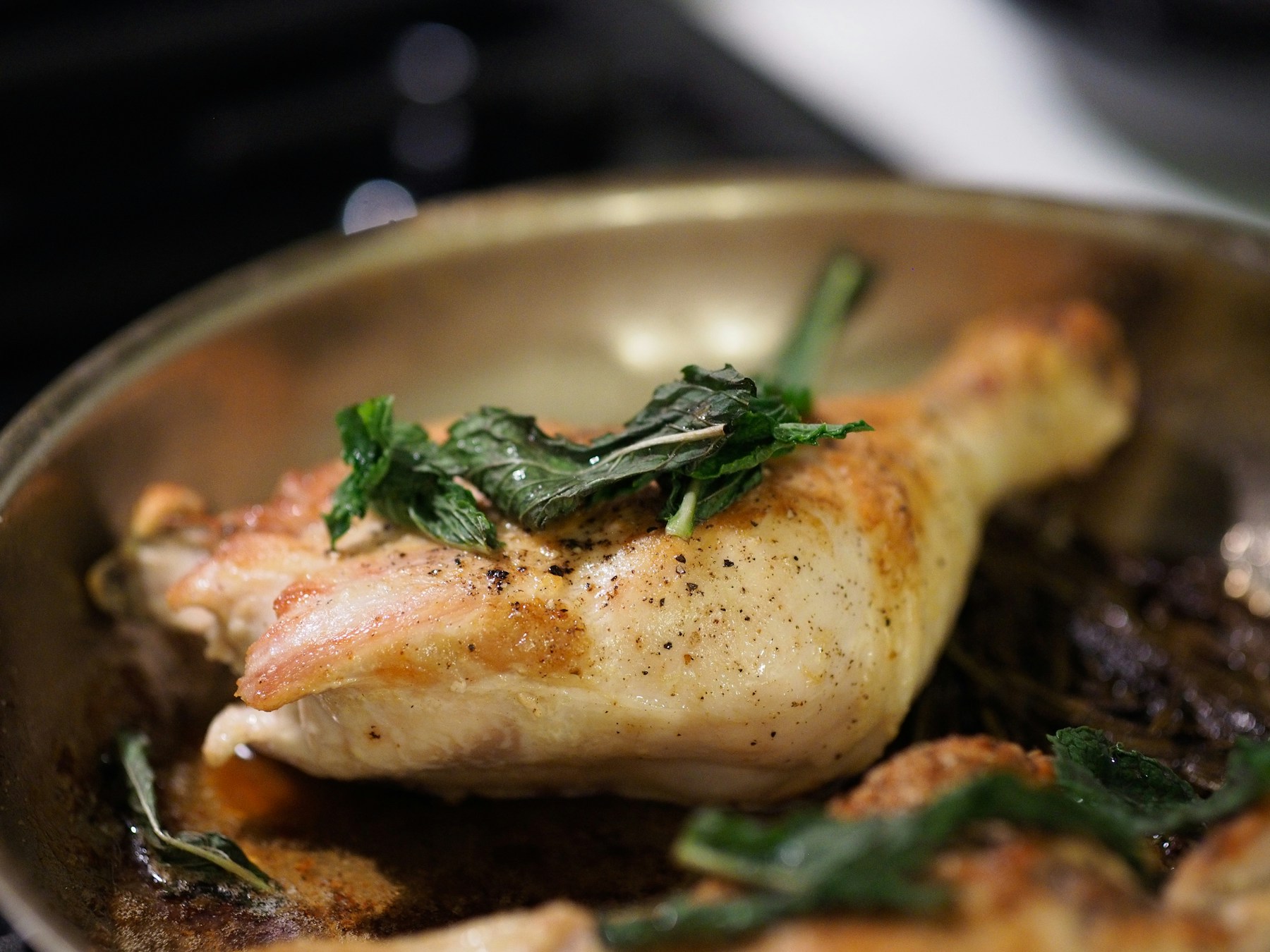 Herb-roasted chicken resting in a dark roasting pan
